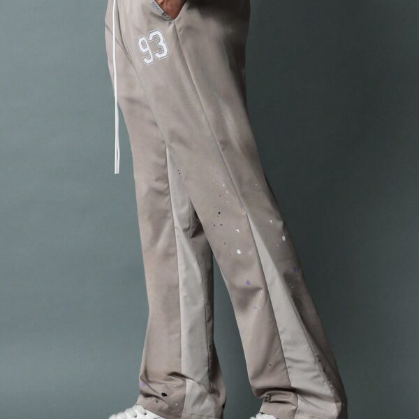 SUMWON Pantalon en nylon avec ajustement évasé, panneau latéral bicolore, imprimé graphique avec éclaboussures de peinture et numéros, avec cordons de serrage