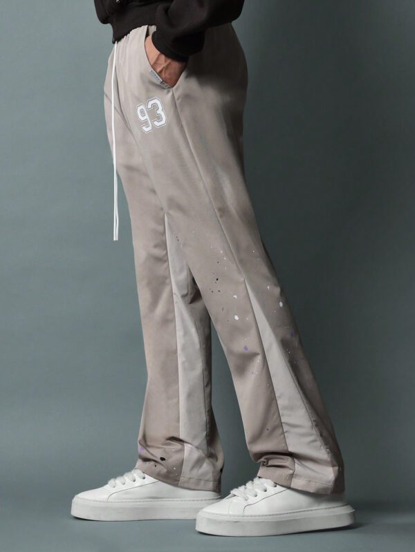 SUMWON Pantalon en nylon avec ajustement évasé, panneau latéral bicolore, imprimé graphique avec éclaboussures de peinture et numéros, avec cordons de serrage