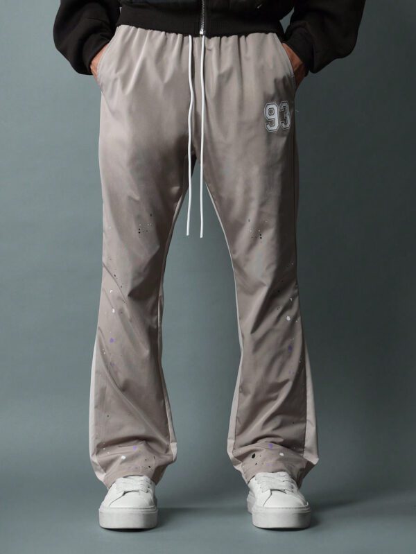 SUMWON Pantalon en nylon avec ajustement évasé, panneau latéral bicolore, imprimé graphique avec éclaboussures de peinture et numéros, avec cordons de serrage – Image 4