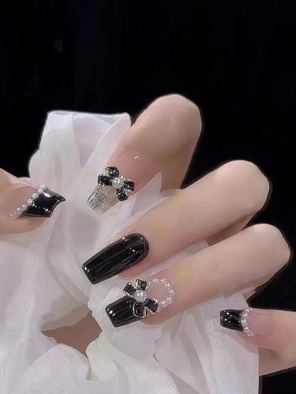 Mettez à niveau votre apparence avec 24pcs Ongles en acrylique noirs en forme d'ongle en forme de cercueil moyen avec nœud papillon et perles fausses, y compris 1 pièce de lime à ongles et 1 feuille d'autocollants d'ongles. Accessoires pour les ongles