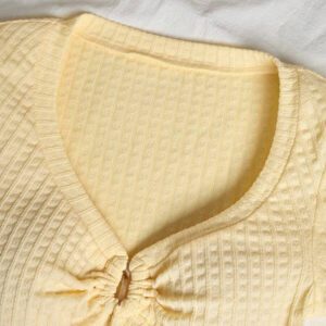 Sunnyshic T-shirt à manches courtes col V avec bouton décoré au centre, en tissu texturé jaune. Extrêmement doux et confortable. Conception minimaliste polyvalente pour les vacances et le quotidien pour les femmes. Été.