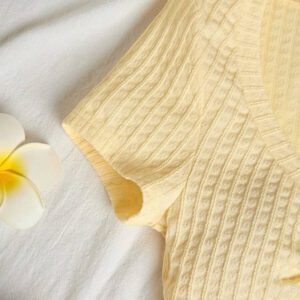 Sunnyshic T-shirt à manches courtes col V avec bouton décoré au centre, en tissu texturé jaune. Extrêmement doux et confortable. Conception minimaliste polyvalente pour les vacances et le quotidien pour les femmes. Été.